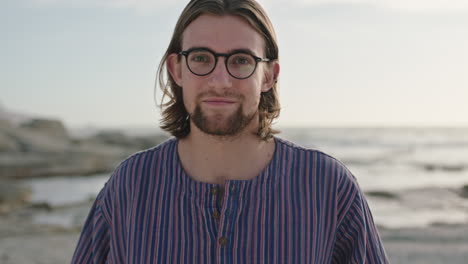 Porträt-Eines-Süßen,-Geekigen-Mannes-Mit-Brille,-Der-Am-Strand-Lächelt-Und-Ein-Gestreiftes-Hemd-Trägt