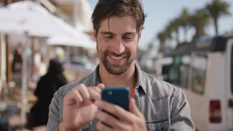 portrait-of-attractive-man-texting-using-phone-on-sunny-beachfront