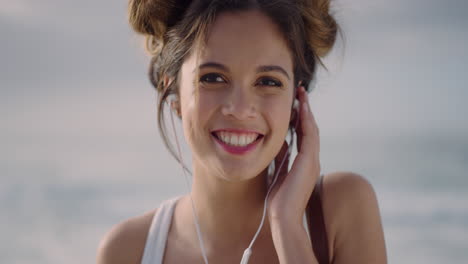 close-up-portrait-of-happy-young-woman-wearing-earphones-smiling-enjoying-listening-to-music-on-seaside-beach-beautiful-hispanic-girl-slow-motion