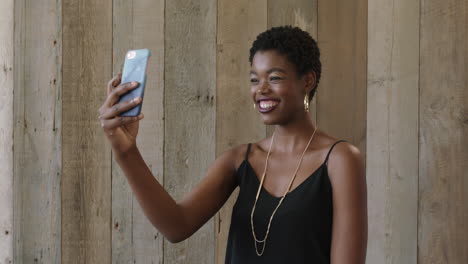 Porträt-Einer-Jungen,-Lebhaften-Afroamerikanischen-Frau,-Die-Posiert-Und-Ein-Selfie-Foto-Mit-Smartphone-Kamera-Technologie-Macht,-Die-Fröhlich-Gesichter-Macht
