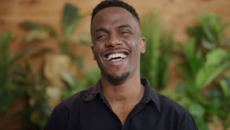 portrait-of-attractive-young-african-american-man-laughing-excited-enjoying-successful-lifestyle-wearing-black-shirt-slow-motion