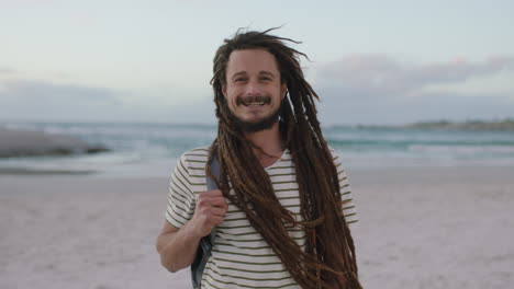 portrait-of-young-confident-man-with-dreadlocks-smiling-cheerful-at-beach