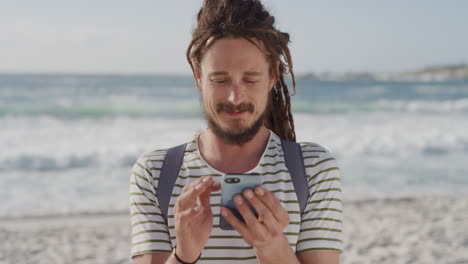 Junger-Touristenmann-Nutzt-Sein-Smartphone,-Schreibt-SMS,-Surft-In-Der-Mobilen-Kommunikation,-Teilt-Strandurlaubsabenteuer-Online-Und-Genießt-Den-Sommerurlaub-An-Der-Sonnigen-Küste