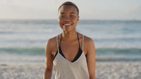 Porträt-Einer-Schönen-Afroamerikanischen-Frau,-Die-Am-Strand-Lacht-Und-In-Die-Kamera-Blickt-Und-Die-Sommerferien-Genießt