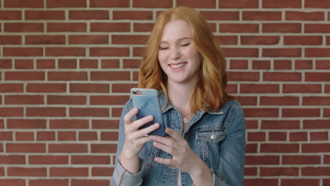 portrait-of-beautiful-red-head-woman-smiling-happy-using-smartphone-texting-on-social-media