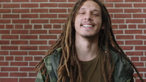 portrait-of-attractive-young-mixed-race-man-with-dreadlocks-laughing-cheerful-relaxed-looking-at-camera
