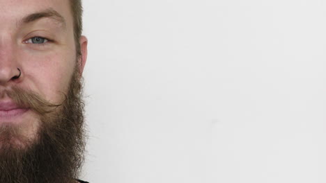close-up-half-face-of-young-man-hipster-beard-smiling-happy-wearing-nose-ring-on-white-background