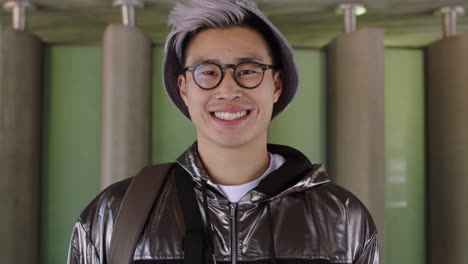 Porträt-Eines-Jungen-Asiatischen-Studenten,-Der-Selbstbewusst-Und-Stolz-Lächelt-Und-Einen-Brillenhut-Trägt