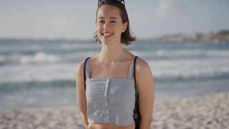portrait-of-attractive-young-woman-smiling-on-beach-looking-cheerful-enjoying-warm-summer-vacation-day-at-seaside-ocean-excited-caucasian-female-tourist