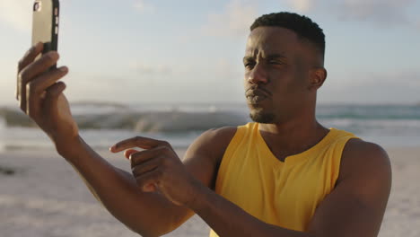 Attraktiver-Junger-Afroamerikanischer-Mann,-Der-Mit-Dem-Telefon-Ein-Lustiges-Selfie-Am-Strand-Macht