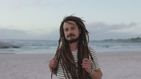 close-up-portrait-of-young-confident-man-with-dreadlocks-smiling-cheerful-at-beach