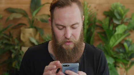 young-caucasian-man-using-smartphone-portrait-of-bearded-hipster-browsing-online-looking-pensive-texting-on-mobile-phone