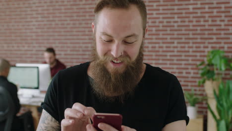 portrait-of-young-bearded-caucasian-man-entrepreneur-texting-browsing-using-smartphone-social-media-app-enjoying-workspace-internet-cafe
