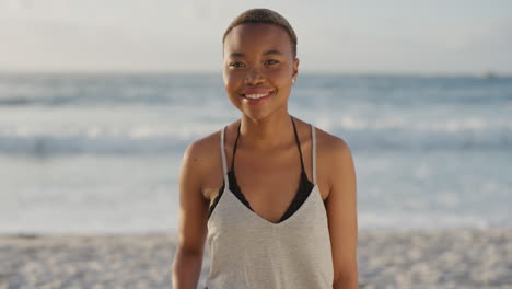 Porträt-Einer-Schönen-Afroamerikanischen-Frau,-Die-Am-Strand-Lächelt-Und-In-Die-Kamera-Blickt-Und-Die-Sommerferien-Genießt