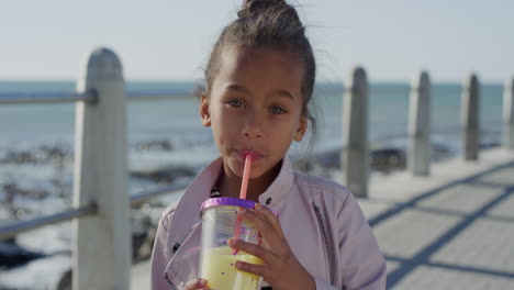 portrait-beautiful-little-girl-drinking-juice-smiling-happy-enjoying-warm-summer-vacation-on-beach-seaside
