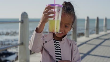 portrait-beautiful-little-girl-holding-juice-smiling-happy-enjoying-warm-summer-vacation-on-beach-seaside