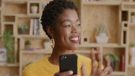 Nahaufnahme-Eines-Porträts-Einer-Stilvollen-Afroamerikanerin,-Die-Ihr-Smartphone-Benutzt-Und-Mit-Der-Hand-Grüßt.-Sie-Genießt-Das-Versenden-Von-SMS-Nachrichten,-Online-Messaging-Und-Die-Kommunikation-Mit-Mobilen-Technologien