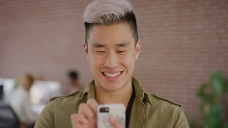 Porträt-Eines-Stilvollen-Jungen-Asiatischen-Mannes,-Der-Sein-Smartphone-Nutzt,-SMS-Schreibt-Und-Online-Nachrichten-Auf-Der-Handy-App-Durchstöbert-Und-Die-Digitale-Kommunikation-Genießt,-Lächelnd-Und-Zufrieden