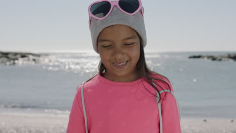 Porträt-Eines-Hispanischen-Mädchens,-Das-Schüchtern-Am-Strand-Lächelt-Und-Rosa-Kleidung-Trägt