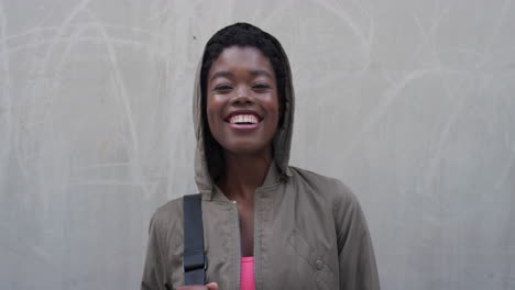 Porträt-Einer-Schönen-Jungen-Afroamerikanischen-Frau,-Die-Glücklich-Lächelt-Und-Eine-Kapuze-Trägt,-Die-Den-Unabhängigen-Urbanen-Lebensstil-Mit-Echten-Menschen-Genießt