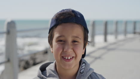 Porträt-Eines-Jungen-Hispanischen-Jungen,-Der-Fröhlich-Lächelt-Und-In-Die-Kamera-Blickt-Und-Den-Sommertag-Am-Strand-Genießt