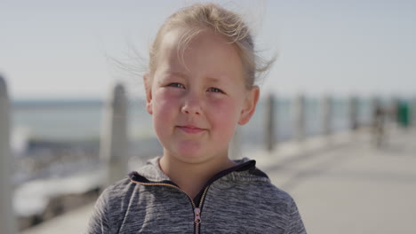 close-up-portrait-of-cute-little-blonde-girl-looking-pensive-serious-at-camera-carefree-child-seaside-beach
