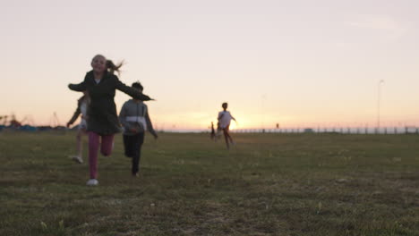 group-of-happy-children-portrait-running-playing-cheerful-in-grass-field-at-sunset-enjoying-fun-games-together