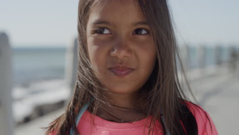 close-up-portrait-young-mixed-race-girl-smiling-happy-enjoying-summer-vacation-on-seaside-beach-wind-blowing-hair-slow-motion