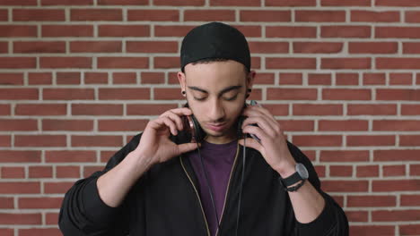 attractive-young-hispanic-man-portrait-of-student-listening-to-music-on-headphones-using-phone