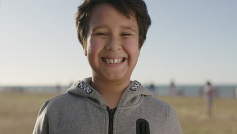 portrait-of-young-hispanic-boy-smiling-cheerful-looking-at-camera-enjoying-summer-day-at-seaside-park