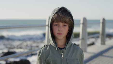 portrait-happy-caucasian-boy-enjoying-ocean-seaside-wearing-jacket-on-windy-sunny-day-slow-motion
