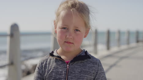 portrait-blonde-little-girl-looking-unhappy-sad-cacuasian-kid-grumpy-on-warm-summer-day-seaside-beach