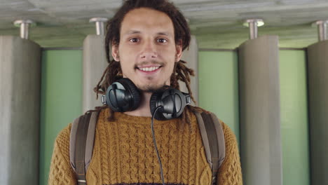 portrait-of-young-mixed-race-man-with-dreadlocks-wearing-headphones-happy-smiling