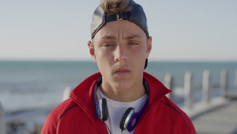 portrait-young-caucasian-teenager-boy-looking-serious-at-camera-on-calm-sunny-seaside