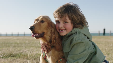 portrait-of-cute-happy-boy-smiling-cheerful-hugging-embracing-pet-dog-enjoying-sunny-day-at-seaside-beach-park