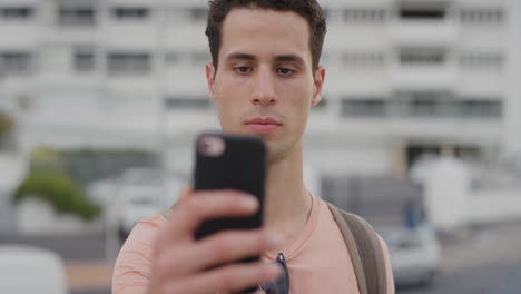 Porträt-Eines-Attraktiven-Jungen-Hispanischen-Mannes,-Der-Mit-Seinem-Smartphone-Ein-Selfie-Foto-Macht-Und-Lächelt-Und-Dabei-Die-Kameratechnologie-Seines-Mobiltelefons-Genießt