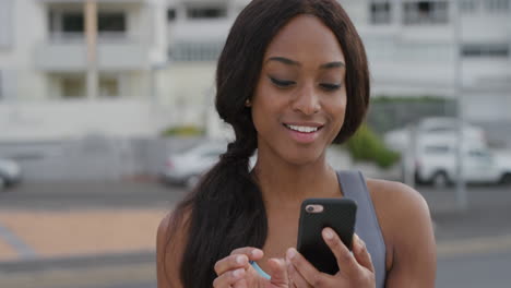portrait-sporty-young-black-woman-using-smartphone-enjoying-browsing-online-messages-texting-on-mobile-app-smiling-satisfaction-slow-motion