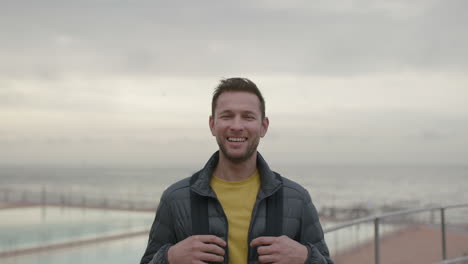 close-up-portrait-of-handsome-man-laughing-cheerful-on-cloudy-seaside