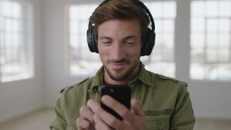 slow-motion-portrait-of-young-attractive-man-enjoying-texting-browsing-social-media-using-smartphone-listening-to-music-wearing-headphones