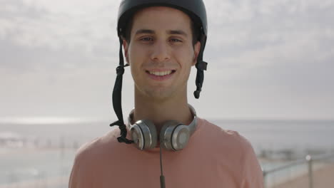 portrait-of-cheerful-young-attractive-man-wearing-helmet-smiling-by-seaside