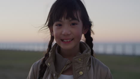Porträt-Eines-Kleinen-Asiatischen-Mädchens,-Das-Fröhlich-Lächelt-Und-Schöne-Sommerferien-Im-Küstenpark-Genießt