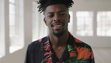 slow-motion-portrait-of-relaxed-african-american-man-smiling-looking-at-camera-enjoying-lifestyle-change-wearing-hawaiian-shirt-in-new-apartment