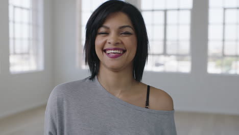 portrait-of-independent-young-mixed-race-woman-laughing-happy-enjoying-positive-lifestyle-move-in-new-apartment-looking-at-camera