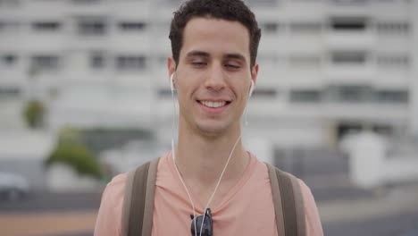 Retrato-Guapo-Joven-Hispano-Estudiante-Sonriendo-Disfrutando-Escuchando-Música-Usando-Auriculares-En-La-Ciudad