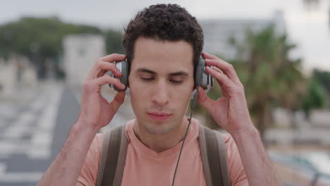 portrait-handsome-young-hispanic-man-puts-on-headphones-enjoying-listening-to-music-on-relaxed-summer-vacation-relaxing-carefree-student-slow-motion