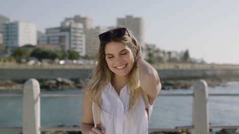 portrait-of-beautiful-young-woman-laughing-cheerful-flirty-looking-to-camera-enjoying-sunny-beachfront