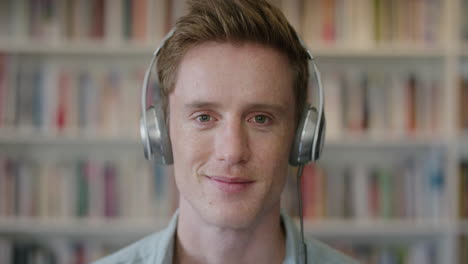 close-up-portrait-relaxed-young-man-student-wearing-headphones-enjoying-listening-to-music-smiling-happy-in-library-bookstore-background-slow-motion