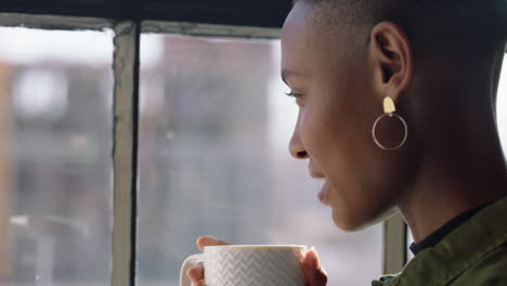 happy-african-american-woman-drinking-coffee-at-home-enjoying-aroma-looking-out-window-planning-ahead-relaxing-black-female-smiling-satisfaction-close-up