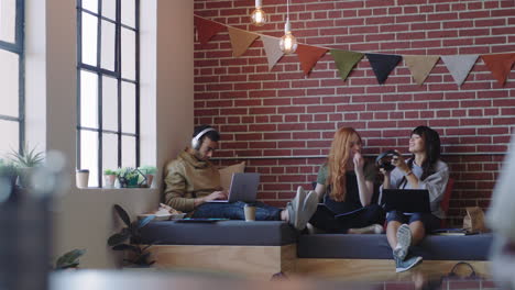 young-diverse-business-students-studying-woman-friends-listening-to-music-together-wearing-headphones-enjoying-working-together-in-relaxed-social-workplace