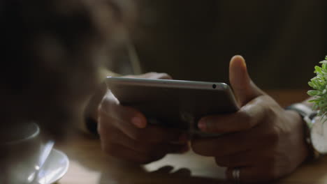 Joven-Afroamericano-Usando-Una-Tableta-En-Un-Café-Navegando-Por-Correo-Electrónico-En-Línea-Leyendo-Mensajes-De-Redes-Sociales-Compartiendo-Estilo-De-Vida-En-Un-Dispositivo-Móvil-Internet-De-Cerca